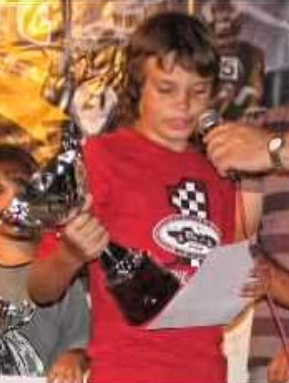 De muy chico, con el trofeo y el micrófono en la premiación de karting